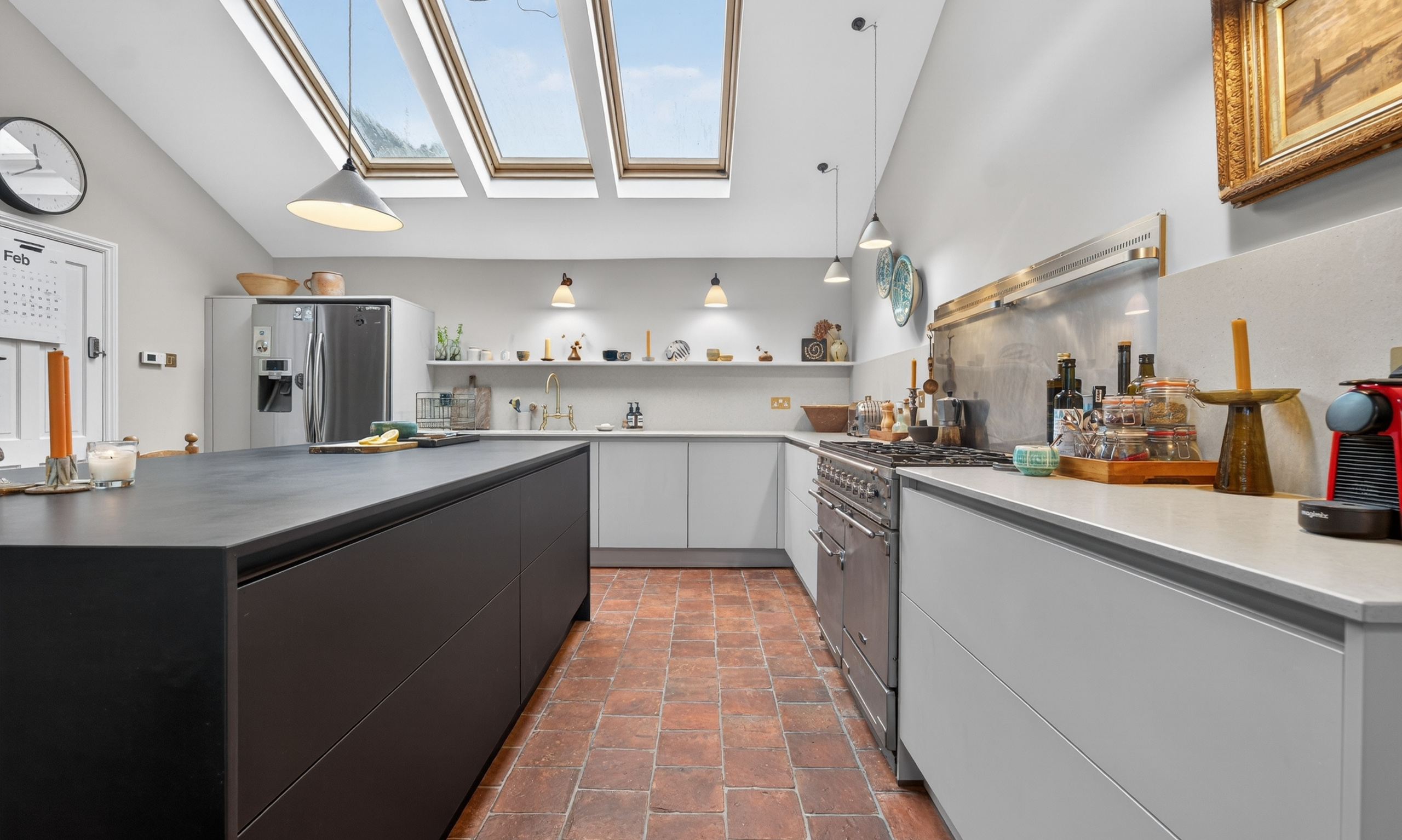 Real customer kitchen designed by Nolte Kitchens Amersham, featuring Velluto cabinetry in Sahara with a contrasting Perfect Plus island in Black, set against original terracotta flooring.