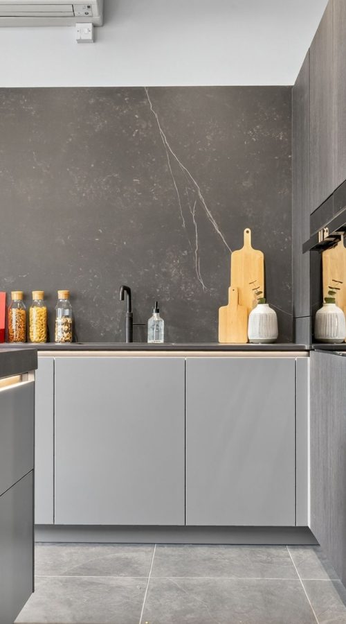 Detail of the neoLodge kitchen display at Nolte Kitchens Bath featuring handleless cabinetry, textured tall units, integrated appliances and illuminated grip rails.