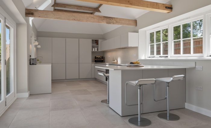 Bright contemporary Nolte Velluto Anti-Fingerprint kitchen in a Kent home, featuring soft neutral cabinetry, a breakfast bar and exposed timber beams.