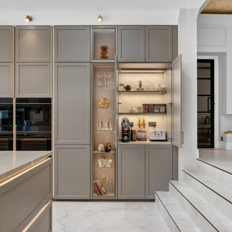 Floor-to-ceiling Nolte cabinetry with glass display shelving and a hidden breakfast station with coffee machine and toaster