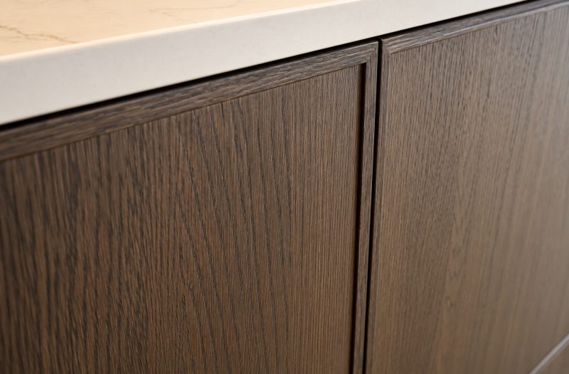 Close-up of neoSlim dark oak framed kitchen doors beneath a white stone-effect worktop at the Nolte Wakefield showroom