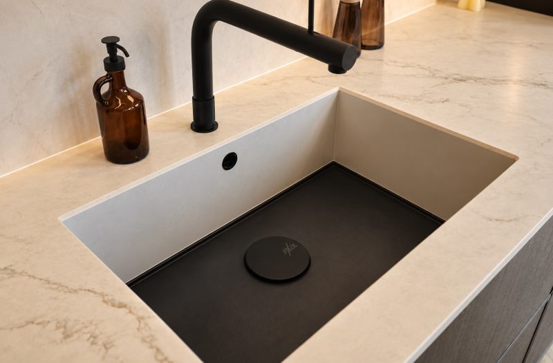 Undermount sink with a matt black tap in a marble-effect worktop above neoSlim dark oak doors at the Nolte Wakefield showroom